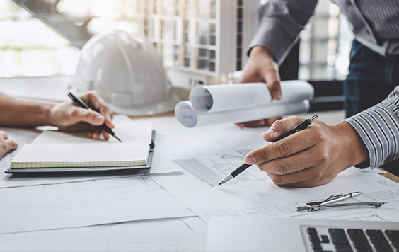 Engineers writing on papers on desk